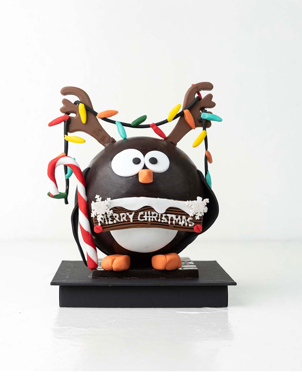 Penguin with RibbonsChocolate & ConfectioneryYour Gift Contains:• 600grams Penguin with Christmas Lights• 10 assorted milk chocolate truffles• Flavors: Pistachio, Hazelnut, Speculoos, Peanut Butter and Roche• Wooden Hammer x 1• Box Size: 16x16x20cmHandlin