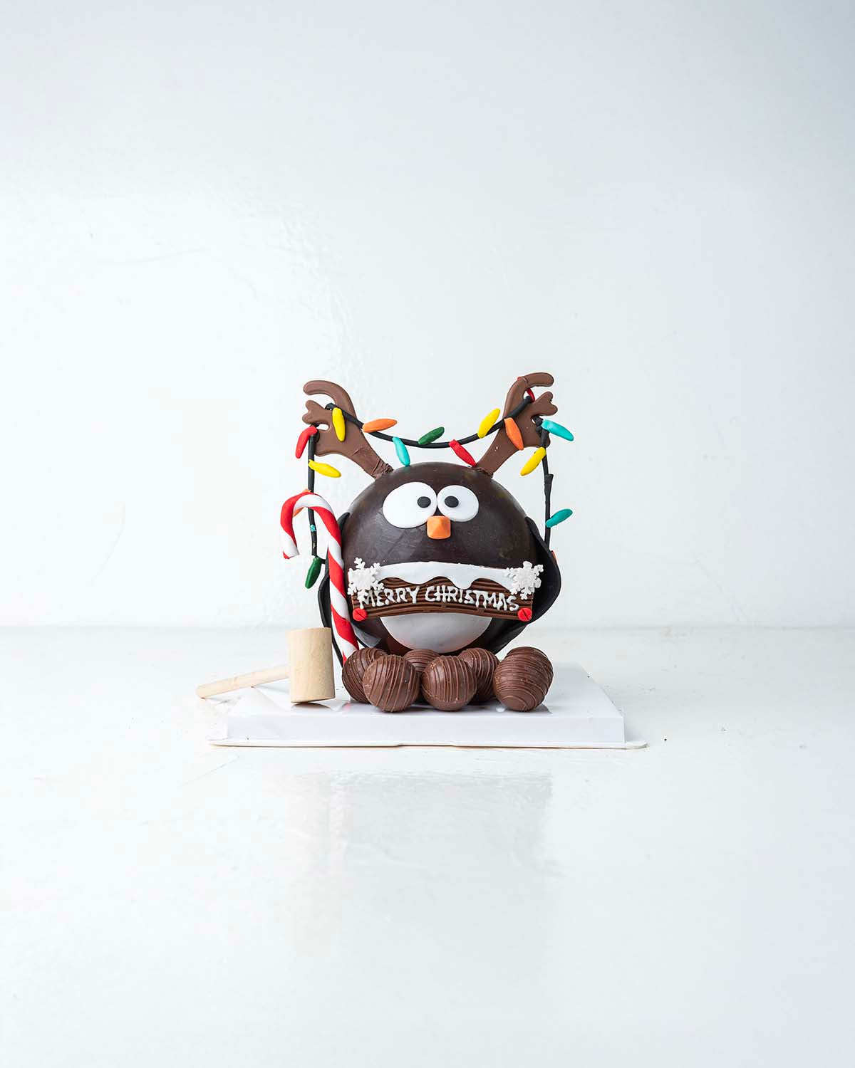 Penguin with RibbonsChocolate & ConfectioneryYour Gift Contains:• 600grams Penguin with Christmas Lights• 10 assorted milk chocolate truffles• Flavors: Pistachio, Hazelnut, Speculoos, Peanut Butter and Roche• Wooden Hammer x 1• Box Size: 16x16x20cmHandlin