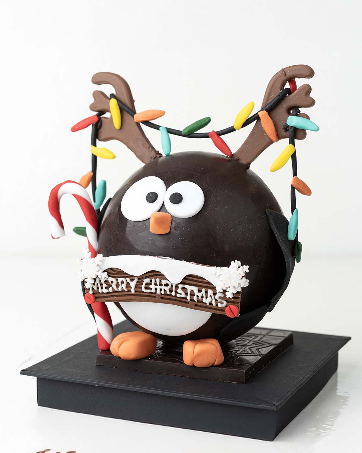 Penguin with RibbonsChocolate & ConfectioneryYour Gift Contains:• 600grams Penguin with Christmas Lights• 10 assorted milk chocolate truffles• Flavors: Pistachio, Hazelnut, Speculoos, Peanut Butter and Roche• Wooden Hammer x 1• Box Size: 16x16x20cmHandlin