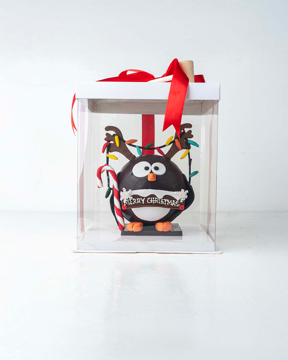 Penguin with RibbonsChocolate & ConfectioneryYour Gift Contains:• 600grams Penguin with Christmas Lights• 10 assorted milk chocolate truffles• Flavors: Pistachio, Hazelnut, Speculoos, Peanut Butter and Roche• Wooden Hammer x 1• Box Size: 16x16x20cmHandlin