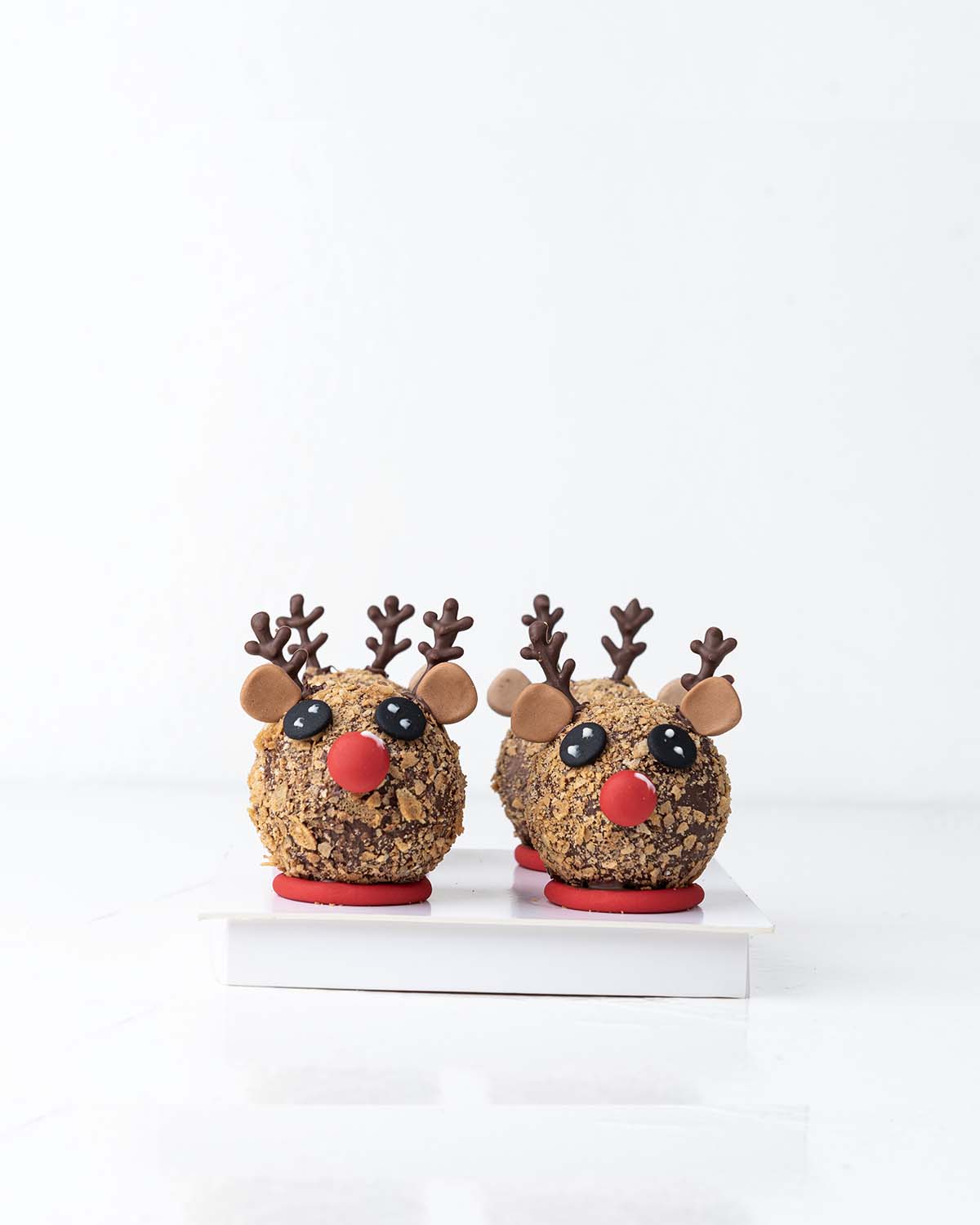 Reindeer Chocolate BombsChocolate & ConfectioneryYour Gift Contains:• 4 Hot Chocolate Bombs Reindeer• Contain hot chocolate mix, marshmallows made in Belgian chocolate• Chocolate Size: 6x6cm• Size of box: 18x18x14cmHandling and Storage• Keep away from dir