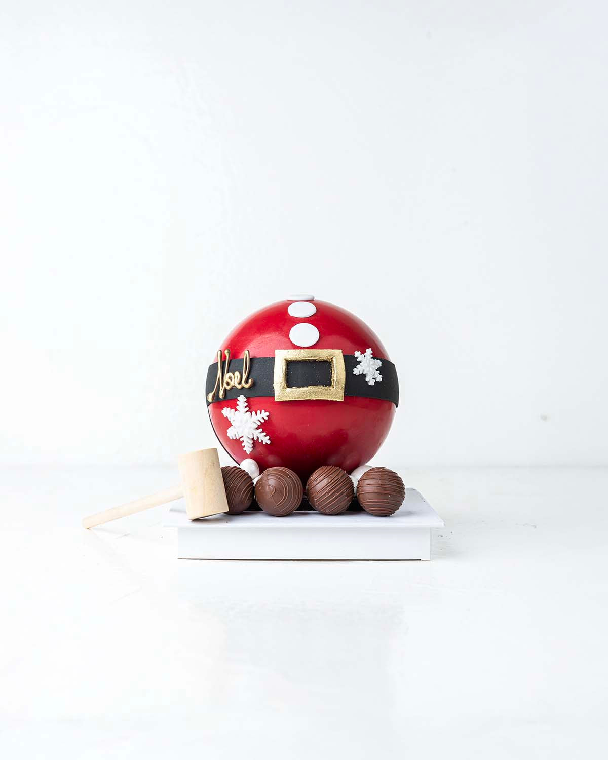 Santa's Belly Filled with TreatChocolate & ConfectioneryYour Gift Contains:• 500grams Pinata Noel Smash Ball• 10 assorted milk chocolate truffles• Flavors: Pistachio, Hazelnut, Speculoos, Peanut Butter and Roche• Wooden Hammer x 1• Box Size: 16x16x20cmHan