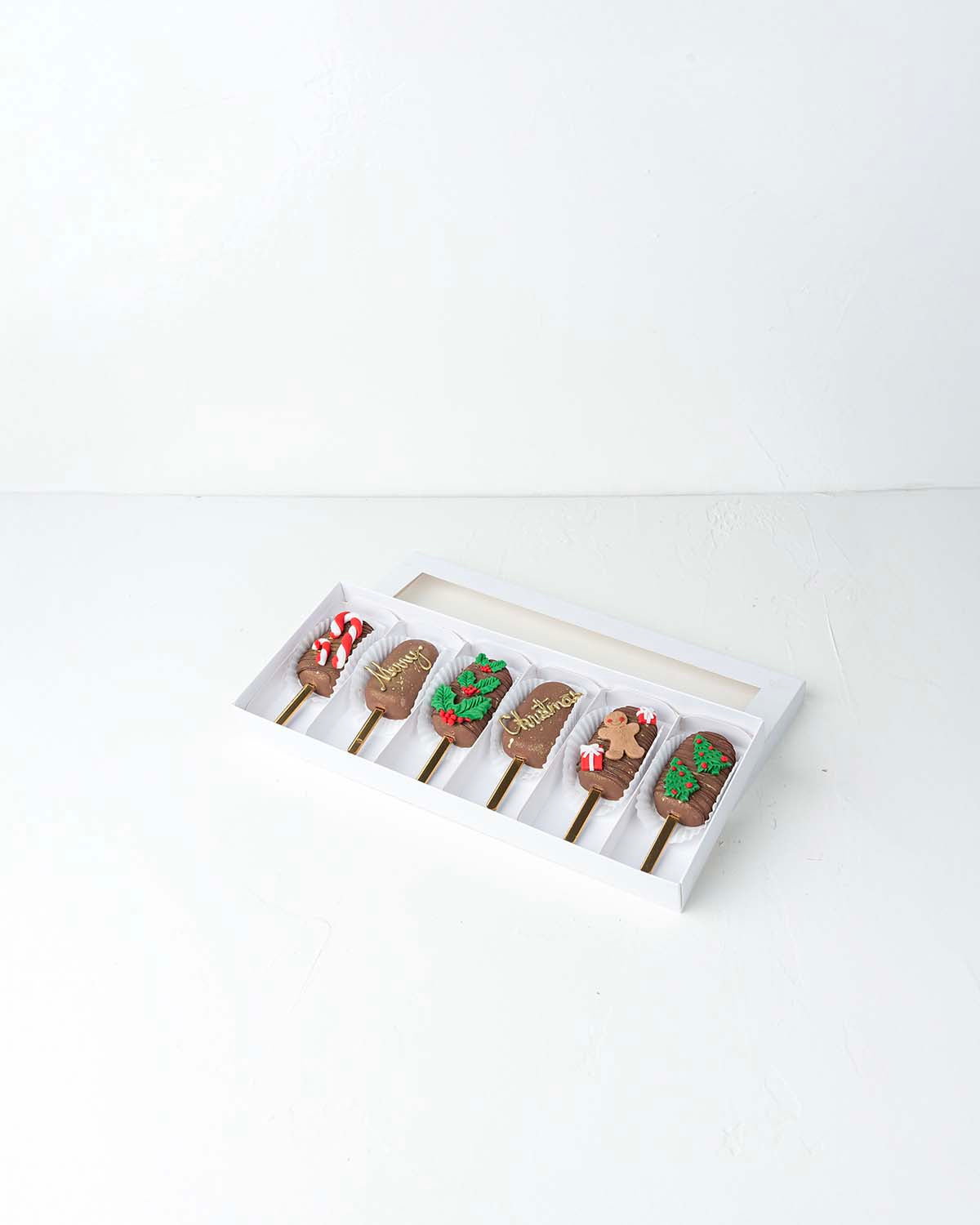 Christmas '24 CakesiclesChocolate & ConfectioneryYour Gift Contains:• 6 Christmas theme cake Cakesicles• Flavor: Chocolate/Vanilla/Red Velvet• Cakesicles Weight: 400g• Box Size: 35×14.5x4cmHandling and Storage• Keep away from direct heat and sunlight• Bes