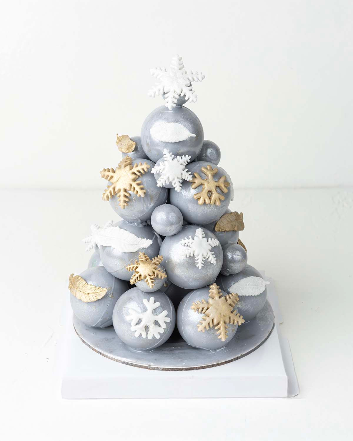 Small and Large Chocolate Bauble TreeChocolate & ConfectioneryYour Gift Contains:• 1000grams Colored Chocolate Bomb and Truffle Tree • Flavors: Pistachio, Hazelnut, Speculoos, Peanut Butter and Roche • Chocolate size: 18x18x25cmHandling and Storage• Keep