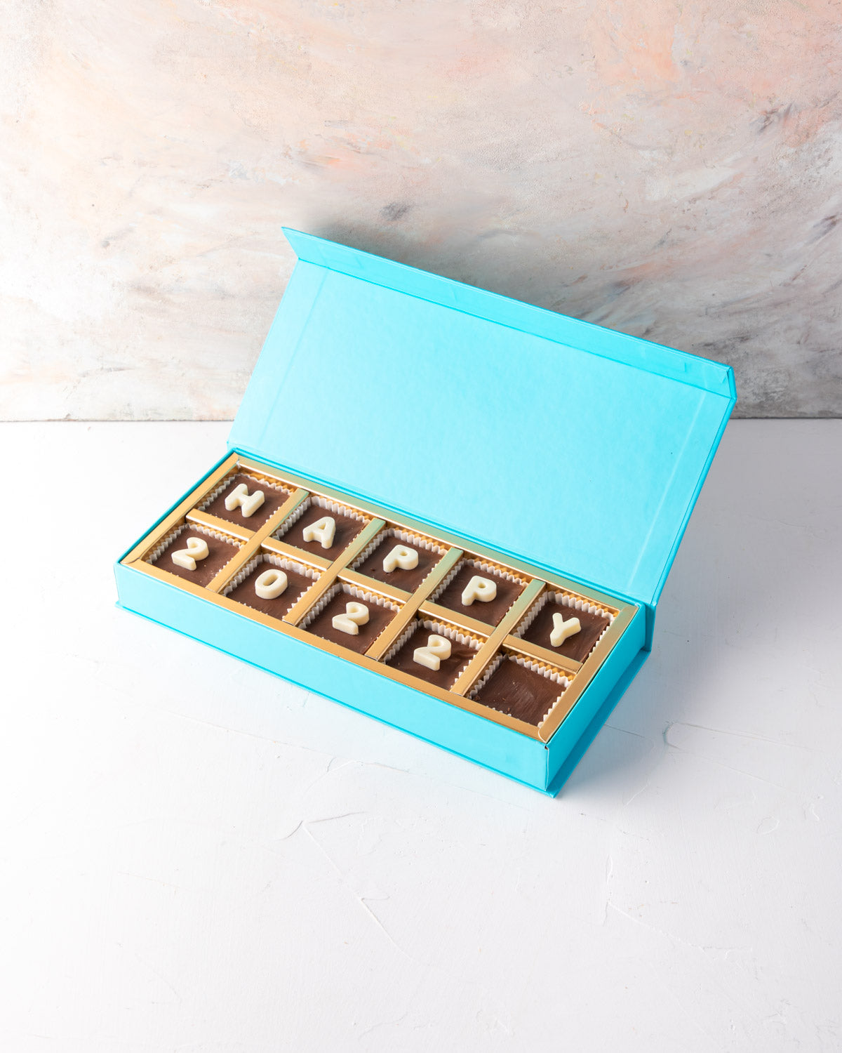 Assorted New Year Greeting Box by NJDChocolate & ConfectioneryYour Gift Contains: • 10 pieces assorted chocolates with message Happy 2022 Box Size: LxBxH: 25x12x4cm HANDLING AND STORAGE Keep away from direct heat and sunlight Best stored between 15-20 °C