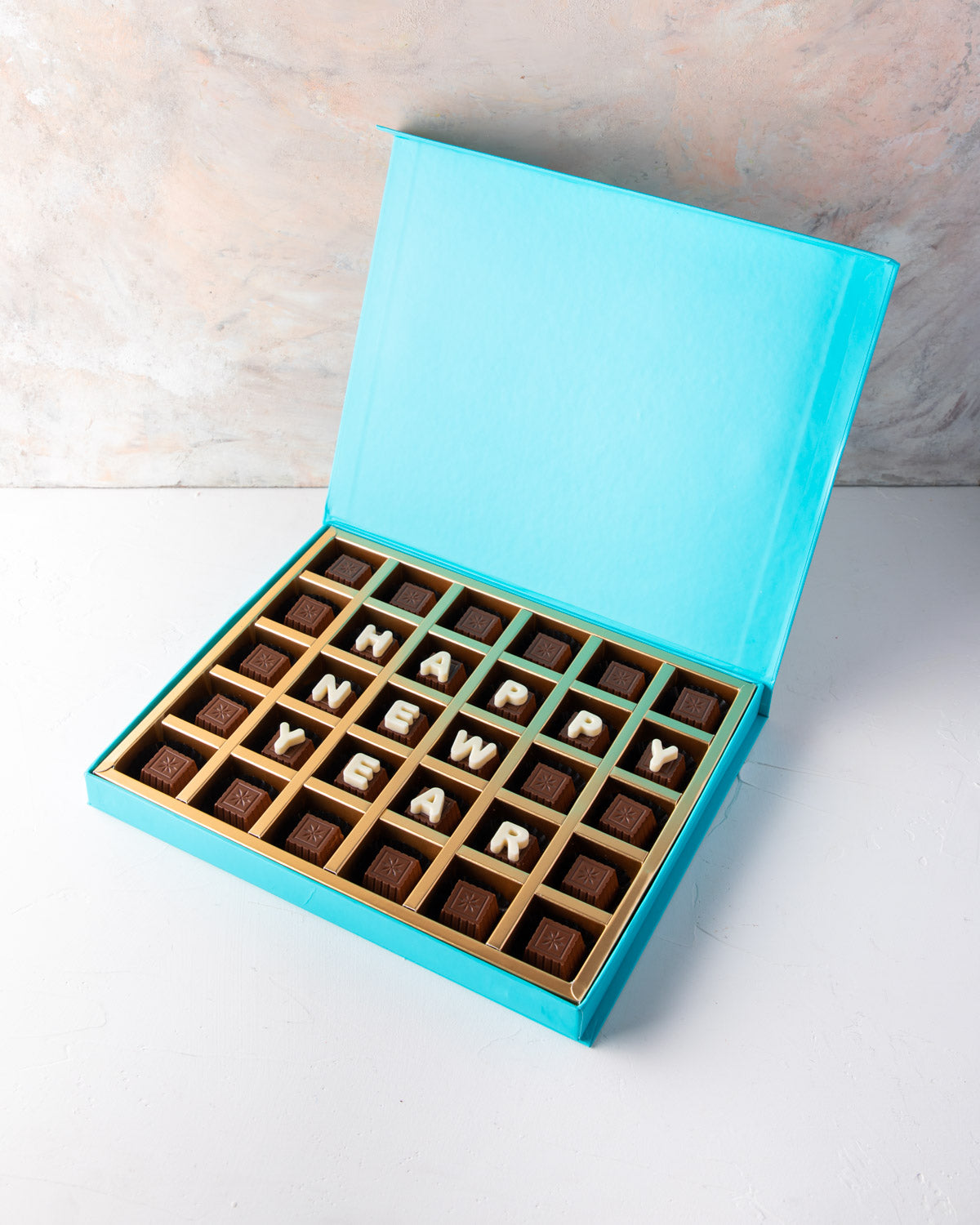 Customizable New Year Chocolates by NJDChocolate & ConfectioneryYour Gift Contains: • 30 pieces assorted Milk chocolate Flavors: Pistachio Praline, Rice Crispy, Rocher, Sepculoos, Hazelnut Praline • Personalized text up to 18 characters (6 in each row) Bo