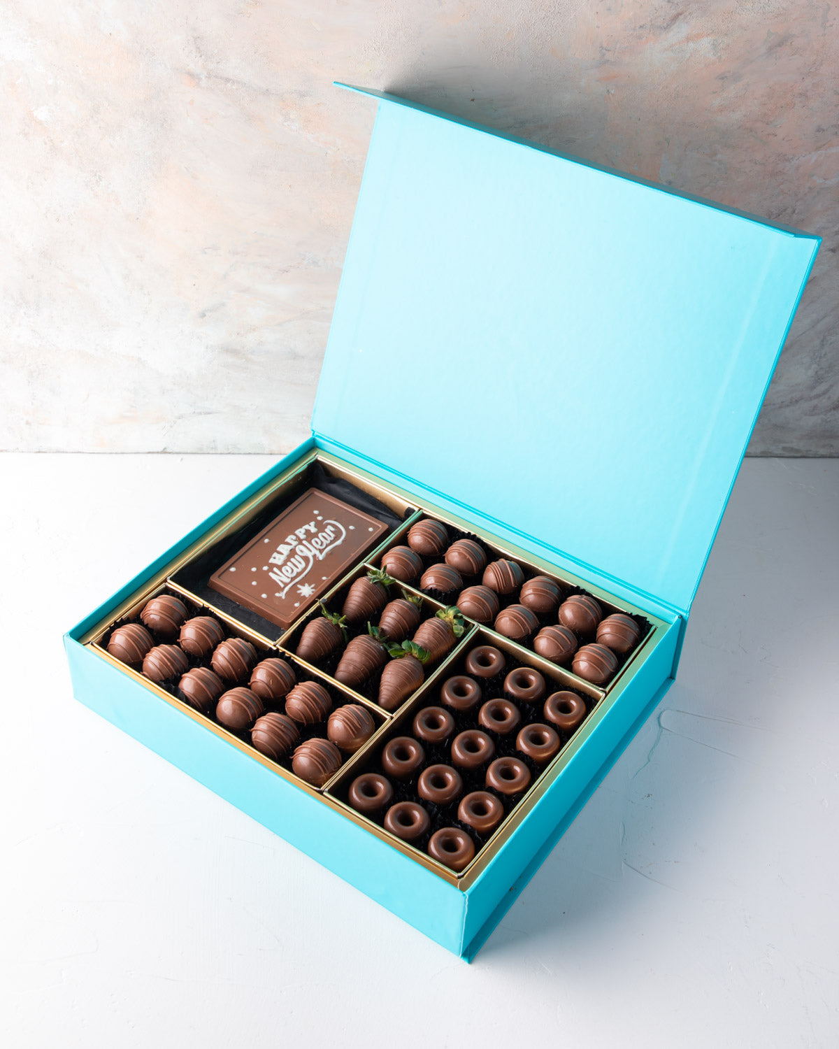 Chocolates and Strawberries New Year Greetings by NJDChocolate & ConfectioneryYour Gift Contains: • 24 pieces Milk Chocolate Truffles in Peanut butter, Rice Crispy, Pistachio, Sepculoos and Hazelnut Gandoua and Pistachio Praline flavors • 50gms Milk Choco