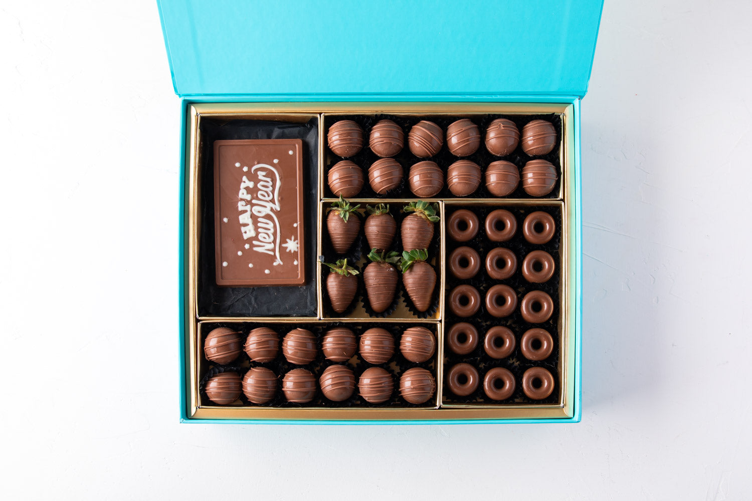 Chocolates and Strawberries New Year Greetings by NJDChocolate & ConfectioneryYour Gift Contains: • 24 pieces Milk Chocolate Truffles in Peanut butter, Rice Crispy, Pistachio, Sepculoos and Hazelnut Gandoua and Pistachio Praline flavors • 50gms Milk Choco