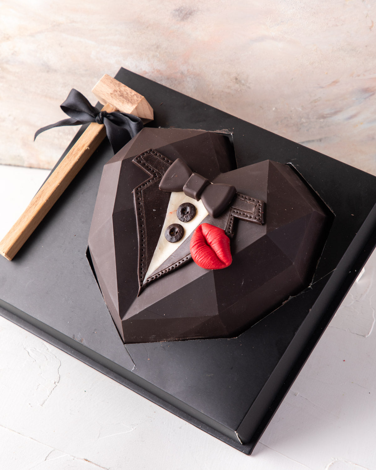 A Gift for Him by NJDChocolate & ConfectioneryYour Gift Contains: • Piñata heart styled as Tuxedo • Made with dark and milk chocolate • 10 pieces assorted milk and dark chocolate truffles (flavors: nuts, praline, and ganache) Box Size: LxBxH: 21x25x9.5cm
