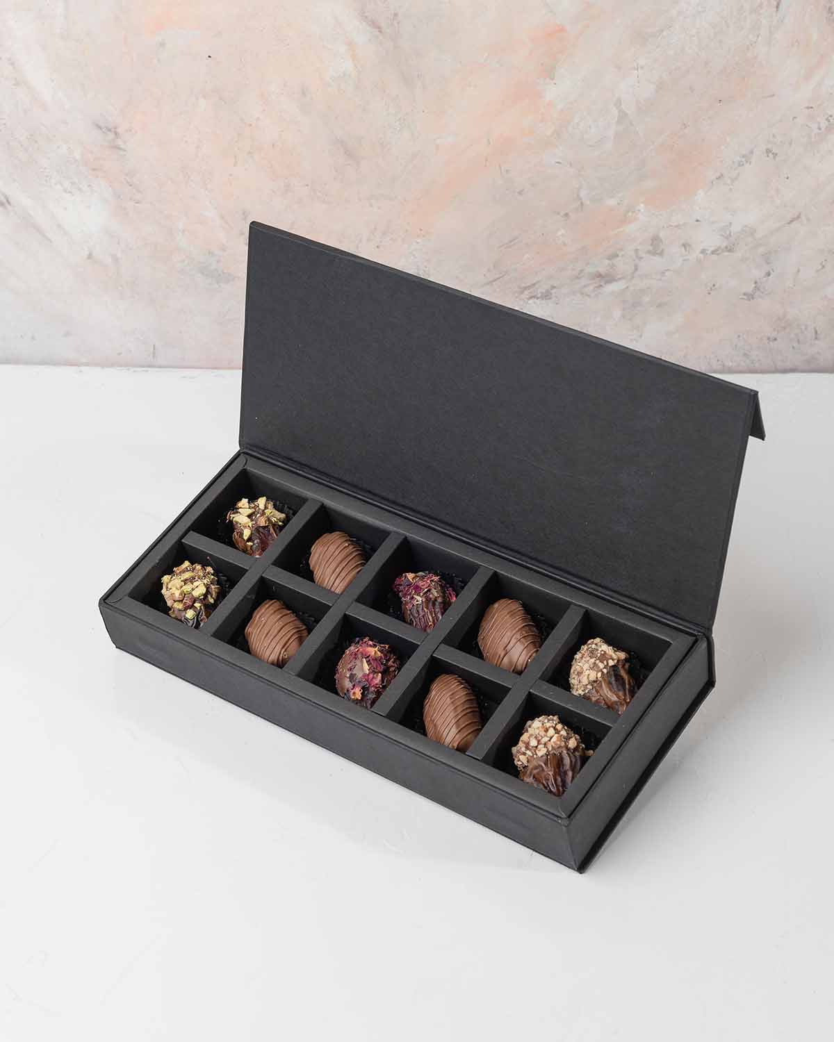 10 Assorted Dates Pack by NJDChocolate & ConfectioneryYour Gift Contains:• 10 x Belgian milk chocolate coated dates• Flavors: Roasted Pistachio, Milk chocolate Rose, Roasted Almonds• Box Size: 28x12x4cmHandling and Storage • Keep away from direct heat and