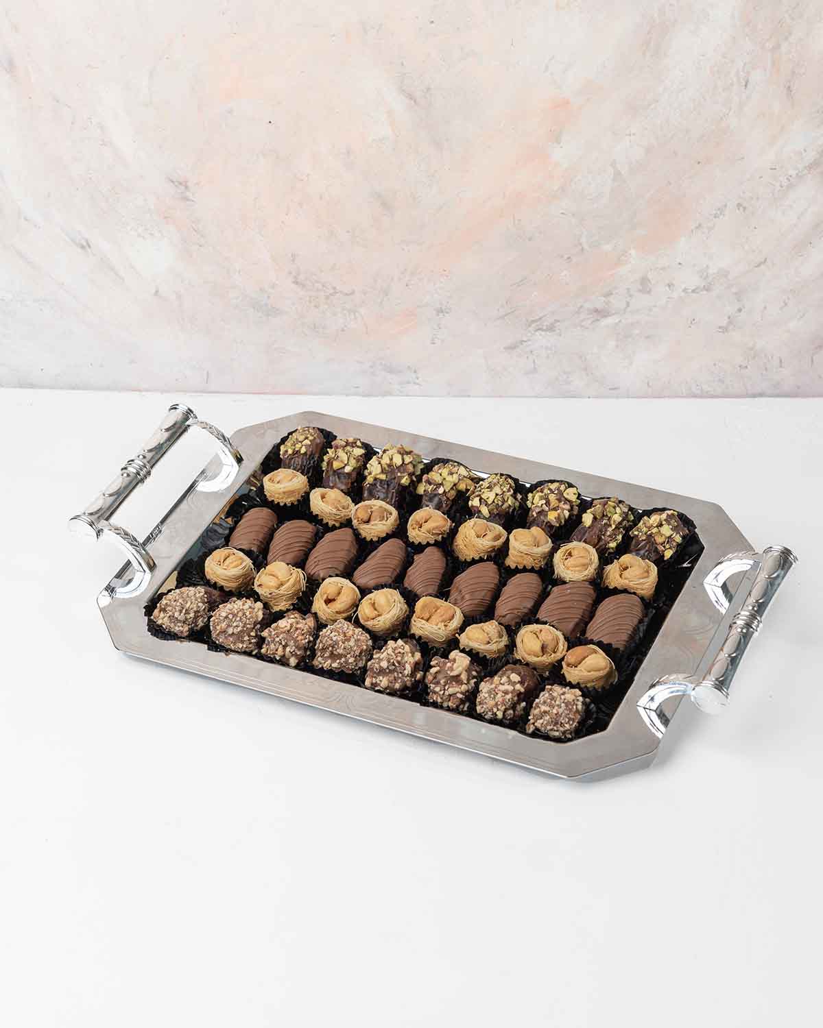 Dates and Baklawa Platter by NJDChocolate & ConfectioneryYour Gift Contains:• 8 x Chocolate Covered Roasted Pistachio Dates• 8 x Chocolate Covered Roasted Almonds Dates• 9 x Milk Chocolate Covered Dates • 16 x Bul Bul Cashew Baklawa Handling and Storage •