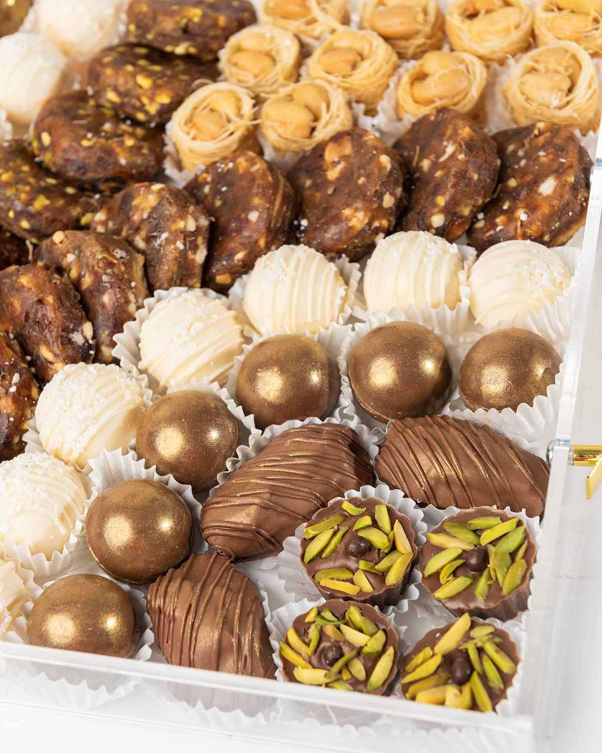 Designer EID Hamper by NJDChocolate & ConfectioneryYour Gift Contains:• 6 x Milk Chocolate Covered Majdoul Dates• 8 x Pistachio flavor Milk Chocolate • 12 x Milk chocolate assorted truffles • 14 x White chocolate truffles • 11 x Sugar free desserts with r