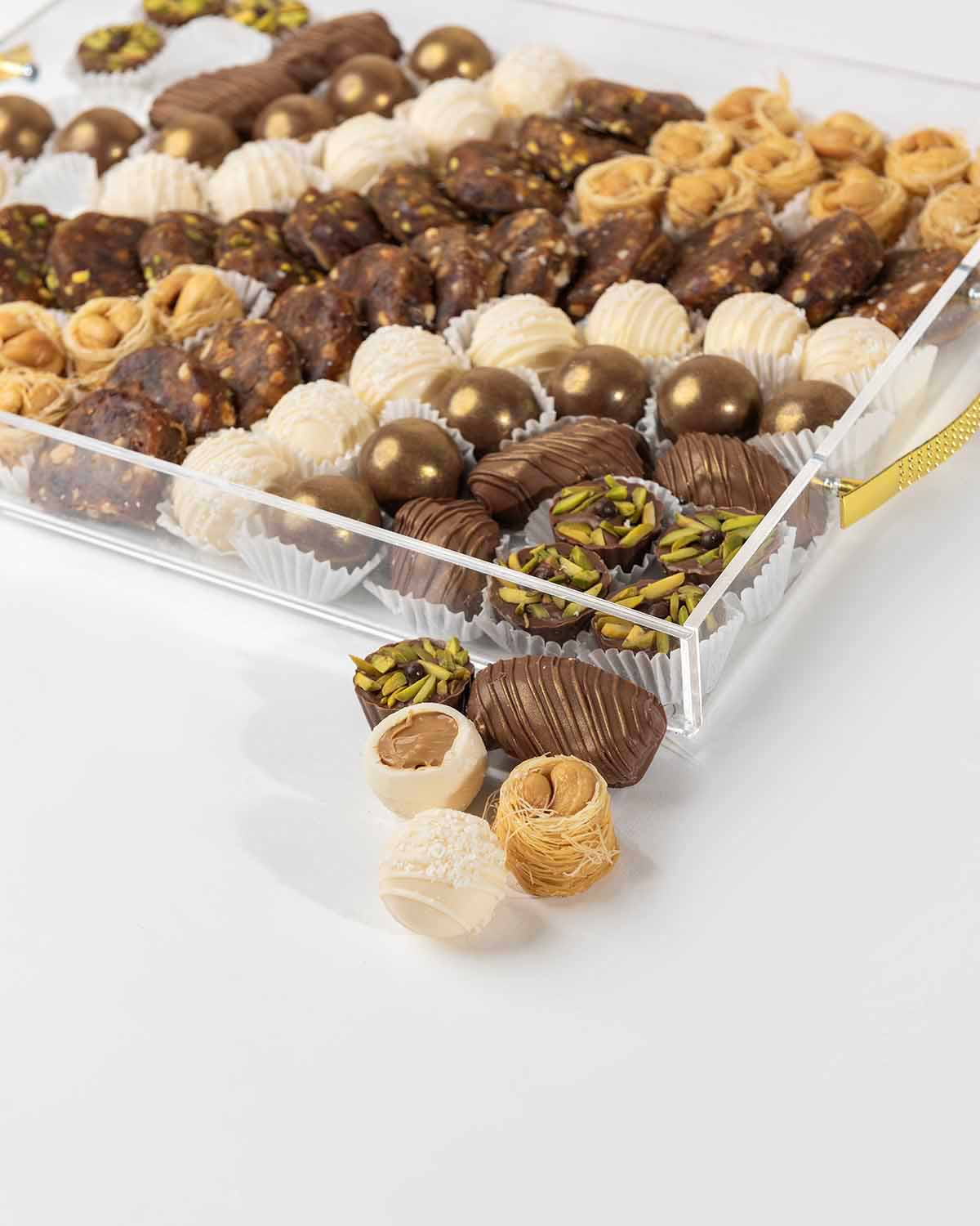 Designer EID Hamper by NJDChocolate & ConfectioneryYour Gift Contains:• 6 x Milk Chocolate Covered Majdoul Dates• 8 x Pistachio flavor Milk Chocolate • 12 x Milk chocolate assorted truffles • 14 x White chocolate truffles • 11 x Sugar free desserts with r
