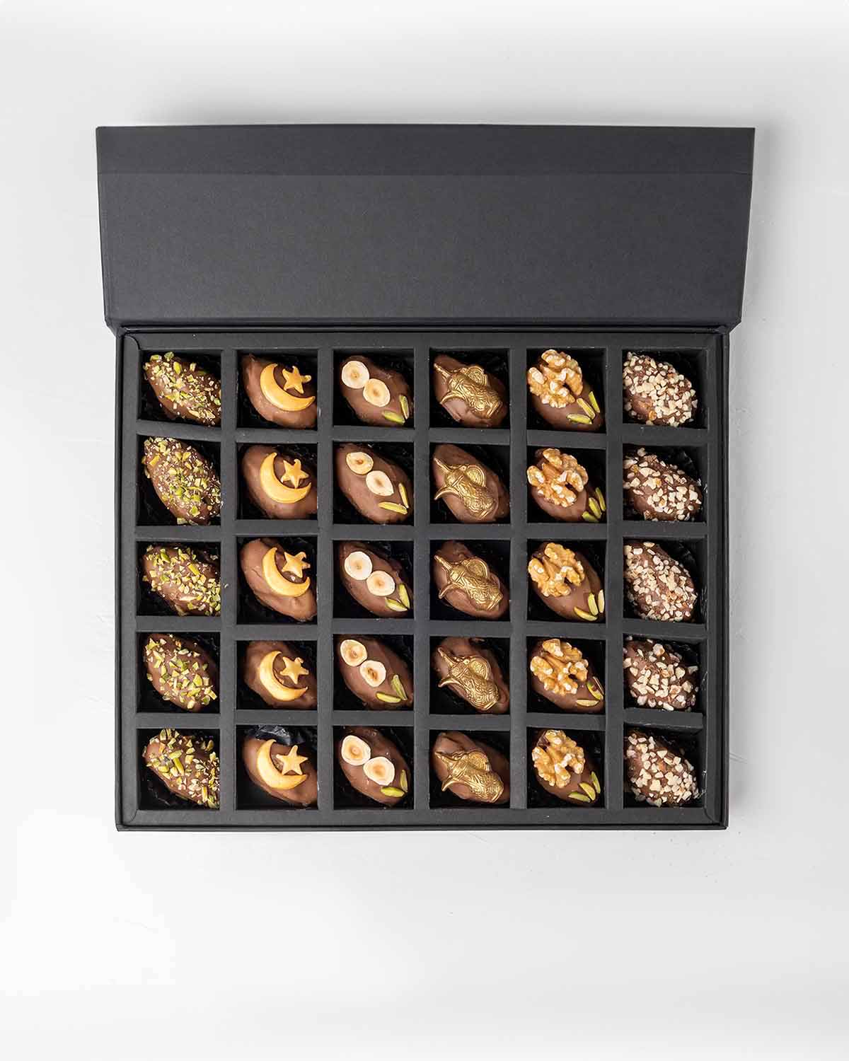 30 Designer Dates by NJDChocolate & ConfectioneryYour Gift Contains:• Belgian Milk chocolate and Pistachio covered dates • 5 x Belgian Milk chocolate covered dates with crescent • 5 x Belgian Milk chocolate covered dates with Macadamia topping• 5 x Belgia