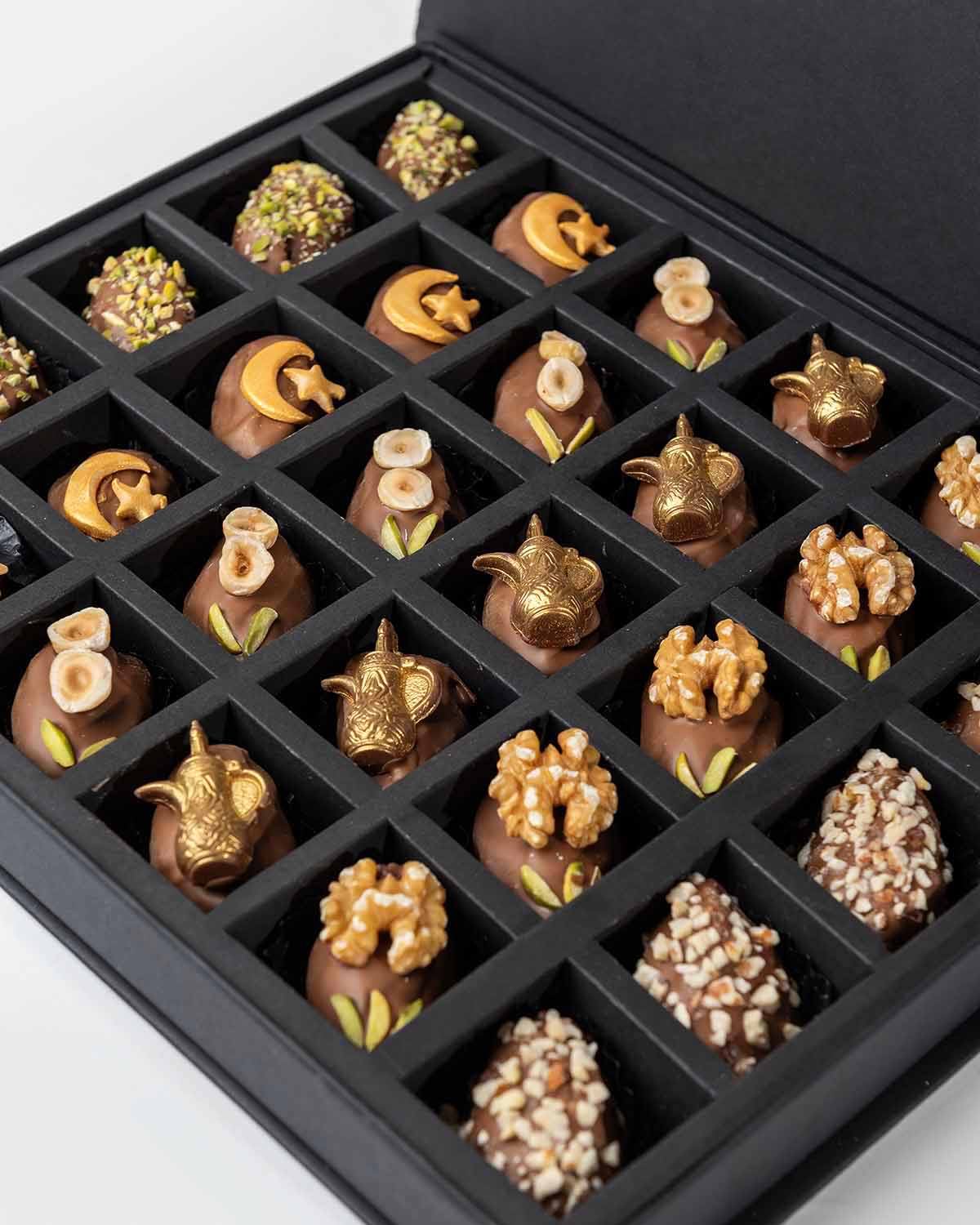 30 Designer Dates by NJDChocolate & ConfectioneryYour Gift Contains:• Belgian Milk chocolate and Pistachio covered dates • 5 x Belgian Milk chocolate covered dates with crescent • 5 x Belgian Milk chocolate covered dates with Macadamia topping• 5 x Belgia