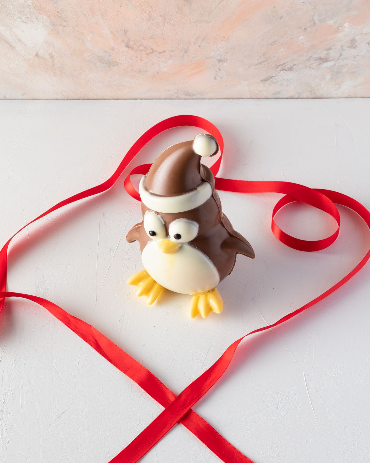 Edible Xmas PenguineChocolate & ConfectioneryYOUR GIFT CONTAINS Chocolate penguin, a cheerful Christmas character made with approx 400gms milk chocolate Chocolate Dimensions: LxBxH: 13x10.5x17cm Flavors: Pure Belgian Milk chocolate and Color chocolate Box