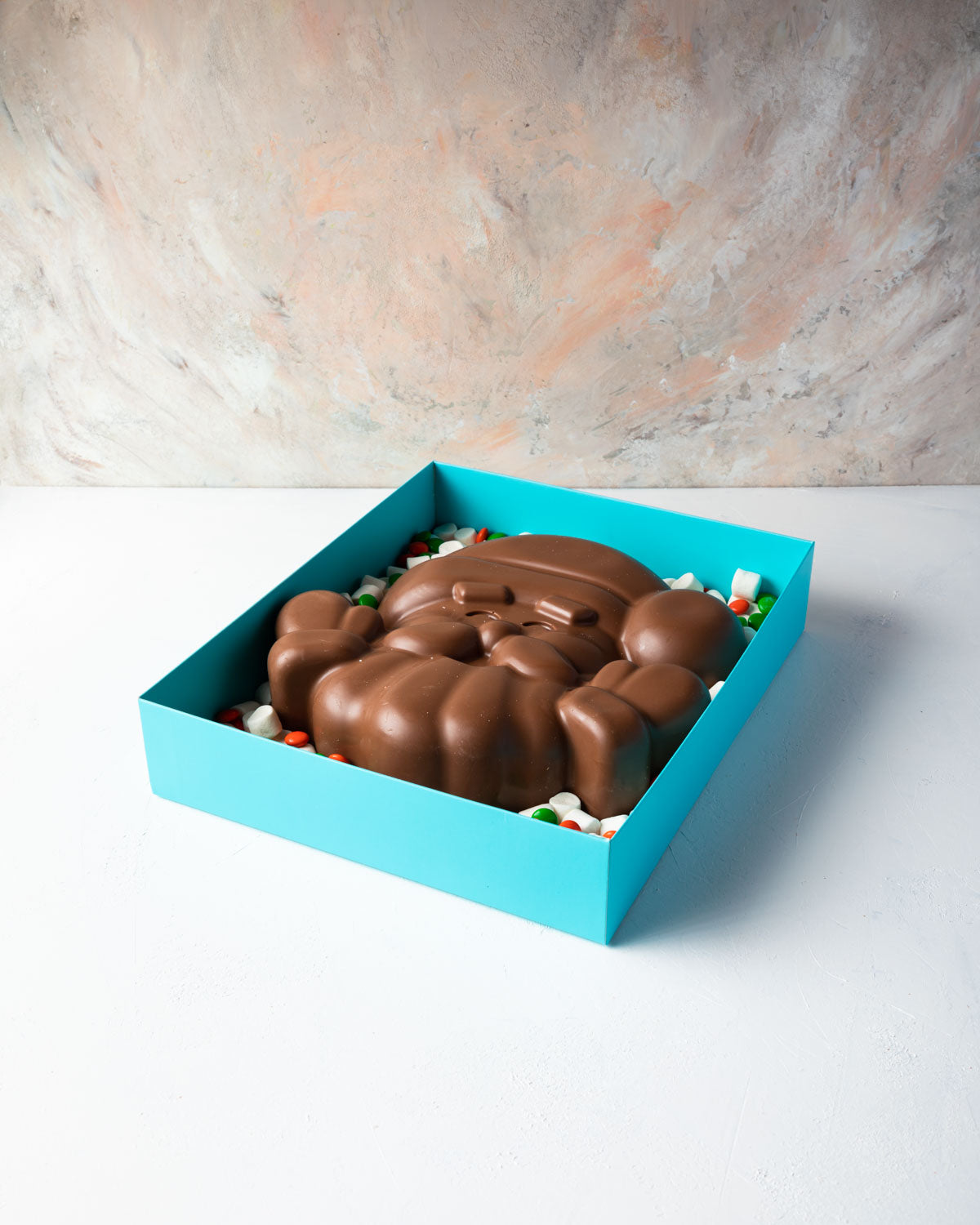 Santa in a Box by NJDChocolate & ConfectioneryYOUR GIFT CONTAINS Approx 1kg milk chocolate, mini marshmallows,orange and green candies Chocolate Dimensions: LxBxH: 25x25x5.5cm Flavors: Pure Belgian Milk chocolate and Color chocolate Box dimensions: LxBxH: