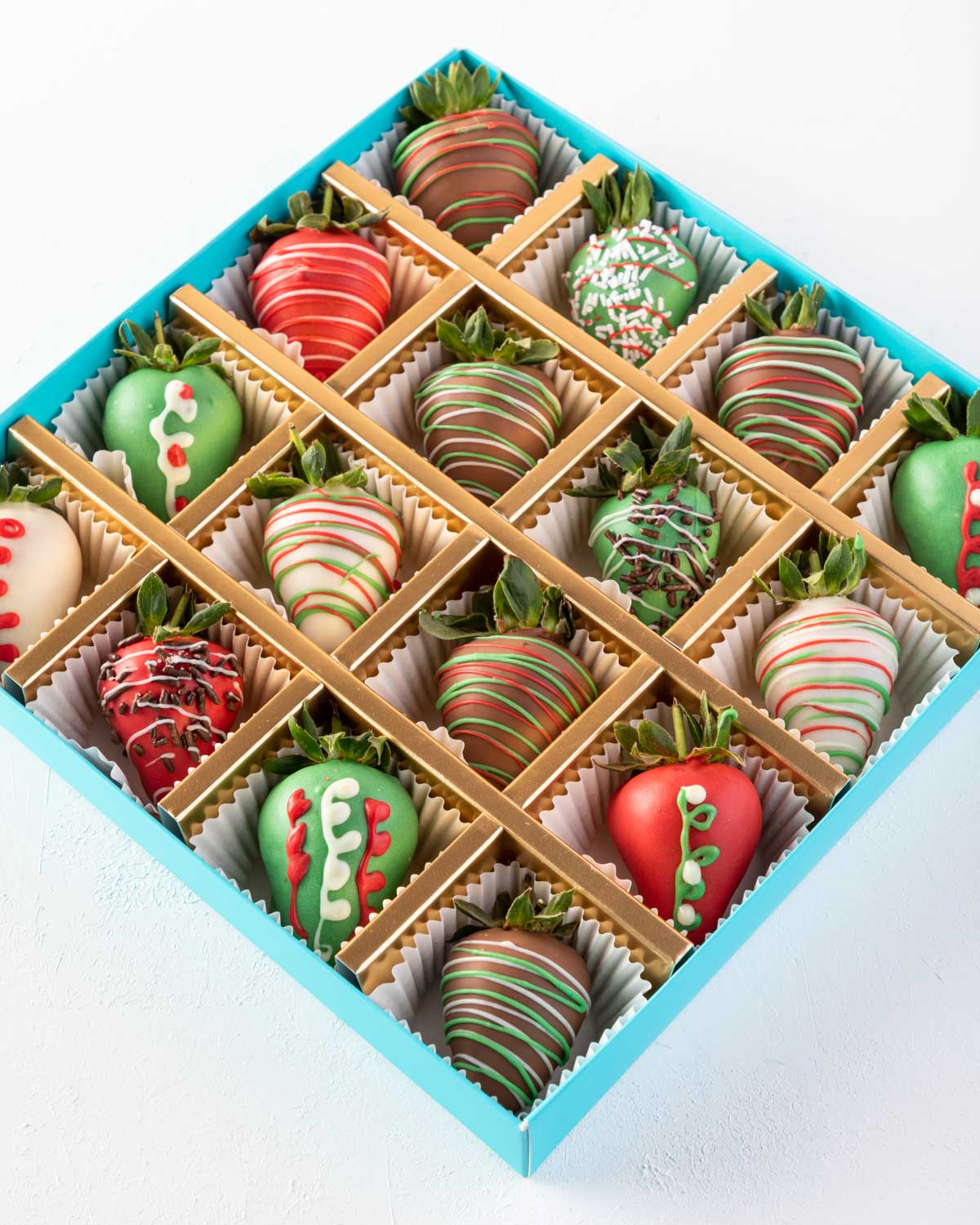 16pcs Xmas StrawberriesChocolate & ConfectioneryYOUR GIFT CONTAINS 16pcs chocolate covered strawberries hand designed in Xmas theme Flavors: Pure, Belgian milk and colored chocolate Box dimensions: LxBxH: 24x24x3.5cm HANDLING AND STORAGE Keep away from di