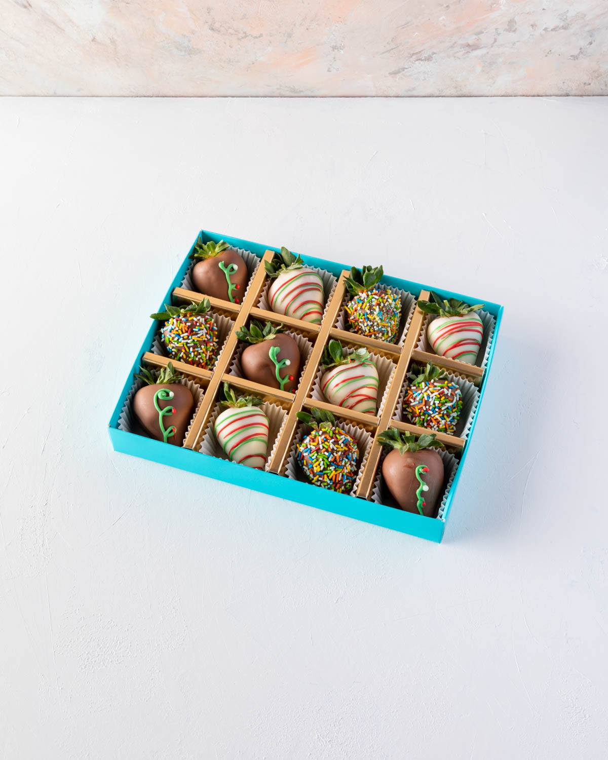 12pcs Xmas Chocolate Strawberry by NJDChocolate & ConfectioneryYOUR GIFT CONTAINS 12pcs of strawberries covered in pure Belgian rich Milk chocolate sprinkled with edible glitters Flavors: Milk and white chocolate, fresh strawberries and edible glitter Box