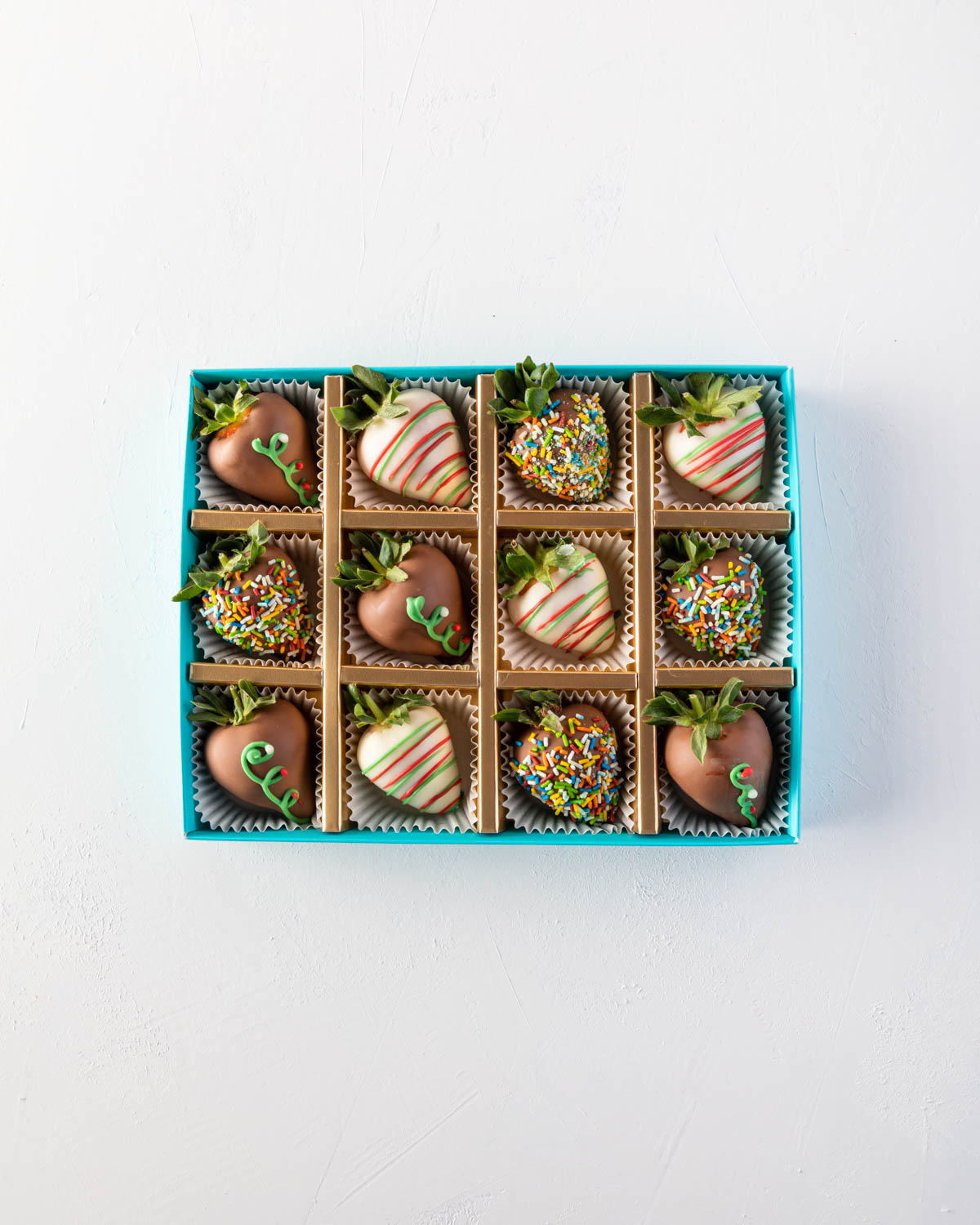 12pcs Xmas Chocolate Strawberry by NJDChocolate & ConfectioneryYOUR GIFT CONTAINS 12pcs of strawberries covered in pure Belgian rich Milk chocolate sprinkled with edible glitters Flavors: Milk and white chocolate, fresh strawberries and edible glitter Box