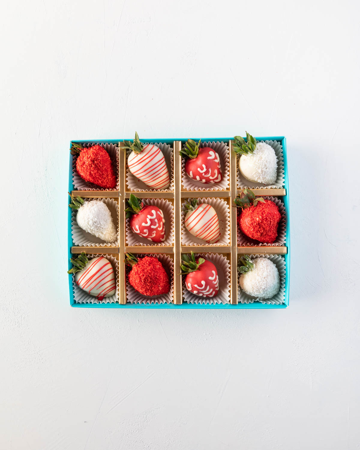 12pcs Red and White Strawberries by NJDChocolate & ConfectioneryYOUR GIFT CONTAINS 12pcs of strawberries covered in pure Belgian rich Milk chocolate sprinkled with edible glitters Flavors: White and colored chocolate, fresh strawberries Box dimensions: Lx