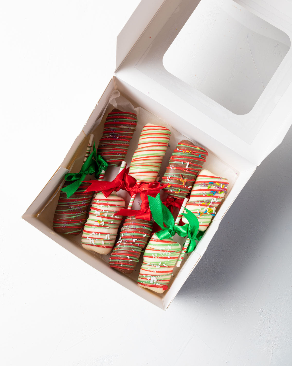 Christmas Mallows by NJDChocolate & ConfectioneryYOUR GIFT CONTAINS 8sticks of chocolate covered marshamallow sticks Flavors: Milk and White Chocolate and Marshmallows Box dimensions: LxBxH: 24x18.5x3.5cm HANDLING AND STORAGE Keep away from direct heat an