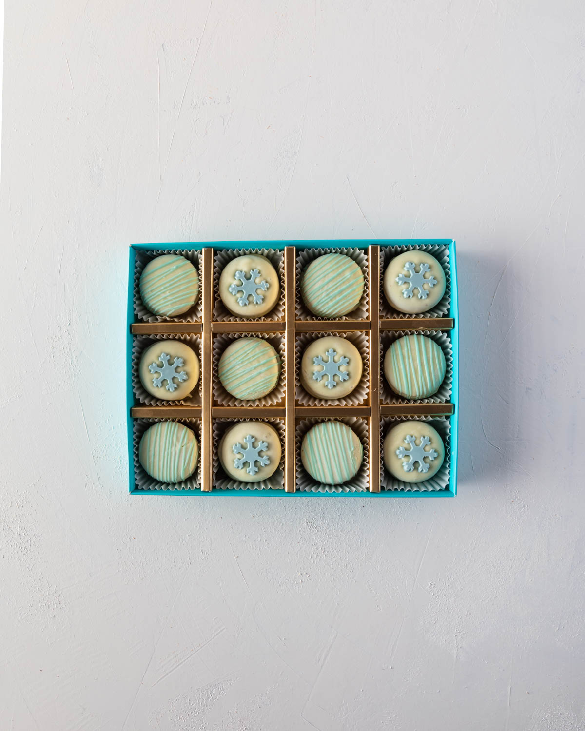 Snowflakes Oreos by NJDChocolate & ConfectioneryYOUR GIFT CONTAINS 12pcs white chocolate covered Oreos with snowflakes and blue swizzles Flavors: Oreo cookies and pure Belgian white chocolate Box dimensions: LxBxH: 24x18.5x3.5cm HANDLING AND STORAGE Keep