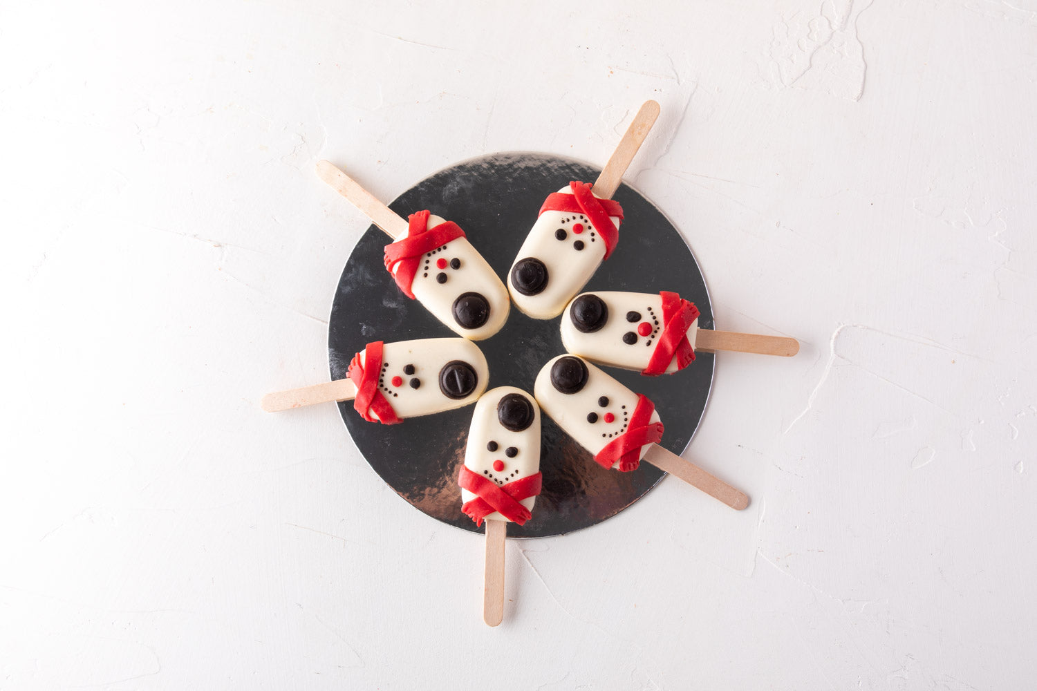 Snowman Cakesicles by NJDChocolate & ConfectioneryYour Gift Contains: • 6 pieces Red Velvet Snowman designed Cakesicles covered in white chocolate Box Size: LxBxH: 23.5x17x18cm HANDLING AND STORAGE Keep away from direct heat and sunlight Best stored betwe