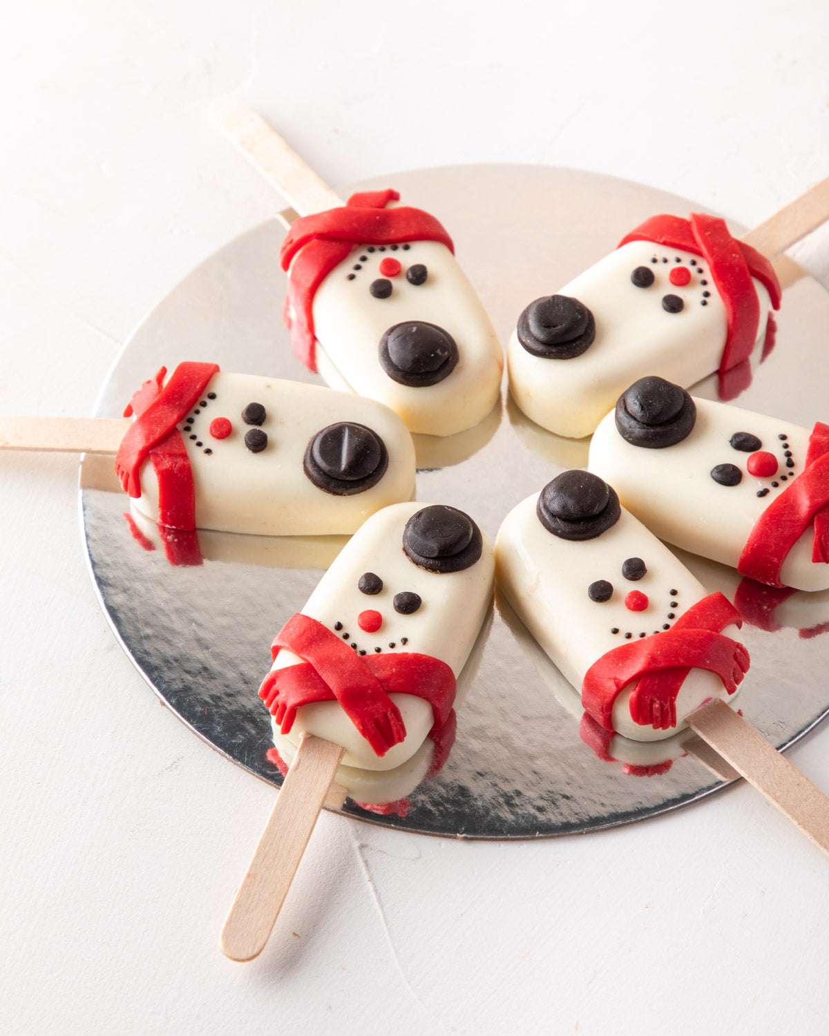 Snowman Cakesicles by NJDChocolate & ConfectioneryYour Gift Contains: • 6 pieces Red Velvet Snowman designed Cakesicles covered in white chocolate Box Size: LxBxH: 23.5x17x18cm HANDLING AND STORAGE Keep away from direct heat and sunlight Best stored betwe