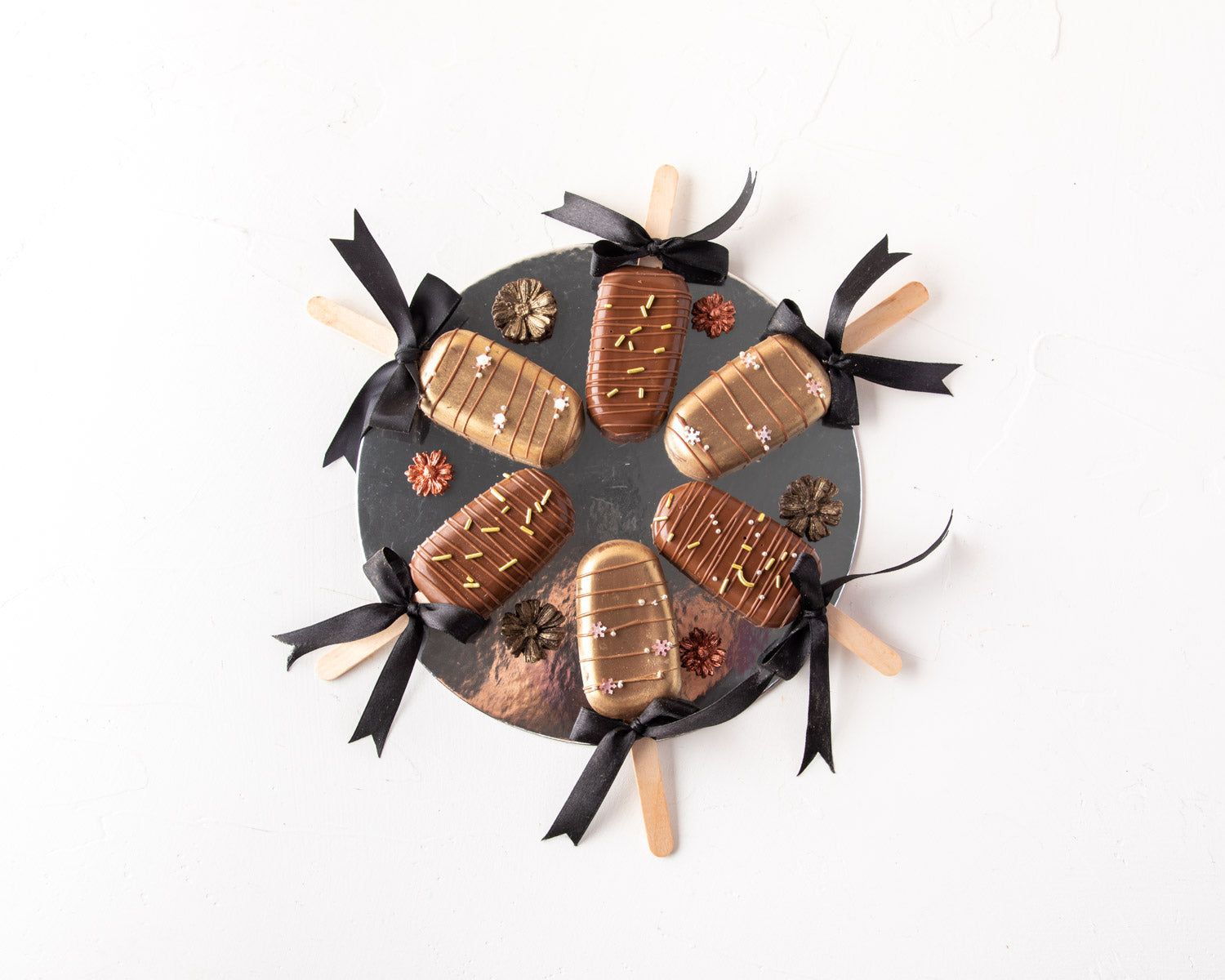 Milk Chocolate Cakesicles by NJDChocolate & ConfectioneryYour Gift Contains: • 6 pieces Red velvet cakesicles in covered in Milk Chocolate Box Size: LxBxH: 23.5x17x18cm HANDLING AND STORAGE Keep away from direct heat and sunlight Best stored between 15-20