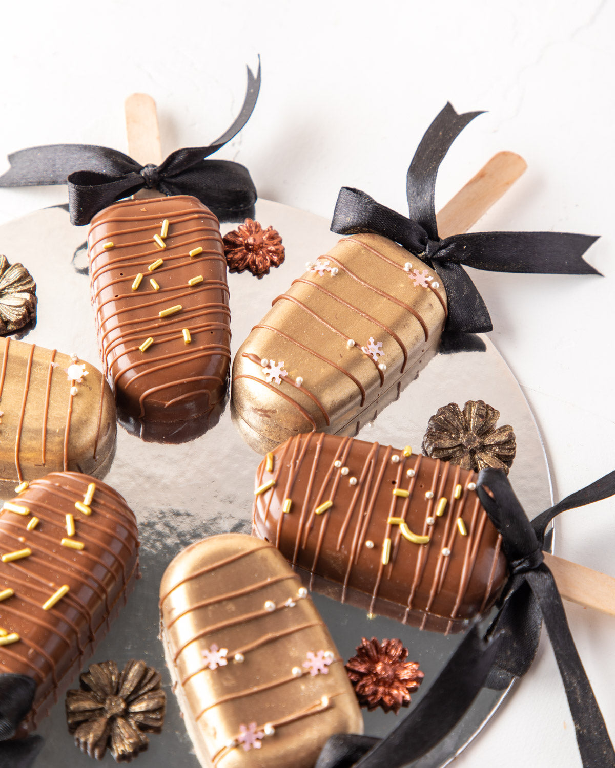 Milk Chocolate Cakesicles by NJDChocolate & ConfectioneryYour Gift Contains: • 6 pieces Red velvet cakesicles in covered in Milk Chocolate Box Size: LxBxH: 23.5x17x18cm HANDLING AND STORAGE Keep away from direct heat and sunlight Best stored between 15-20