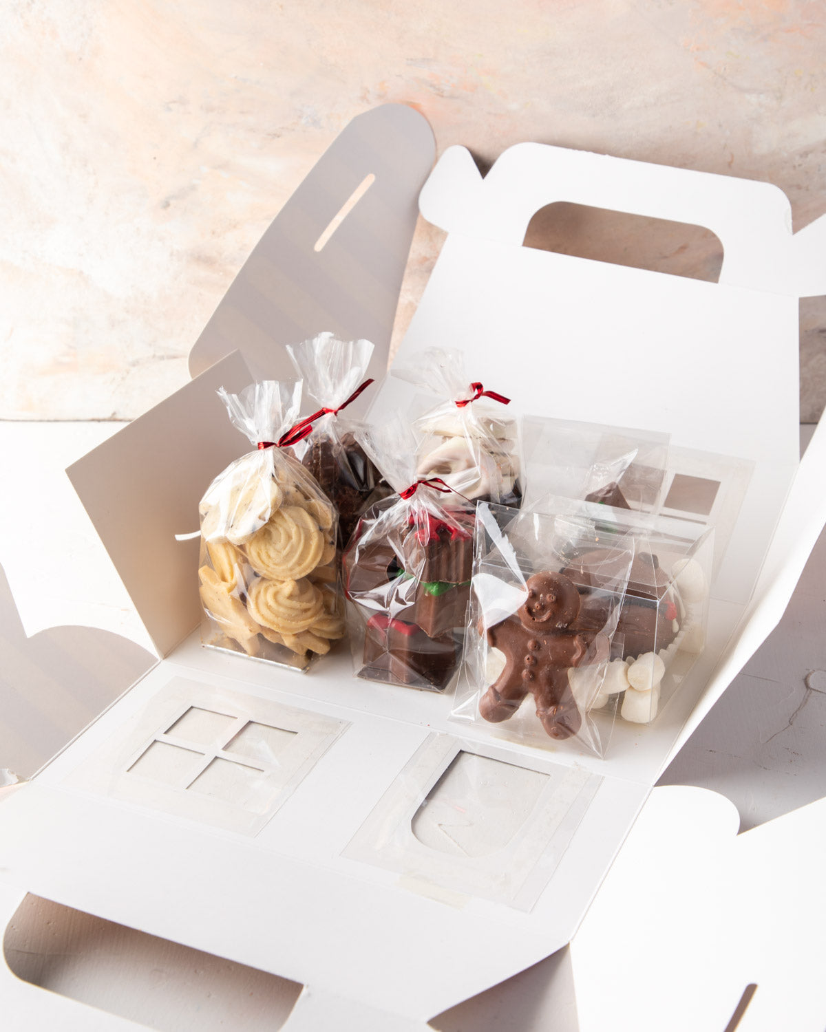 Christmas Treat box by NJDChocolate & ConfectioneryYour Gift Contains: • 1 pack freshly baked cookies • 1 hot chocolate bomb • 1 pack milk and dark chocolate covered Oreos • 1 pack milk chocolate ginger man • 1 pack chocolate brownie bites • 1 pack Christ