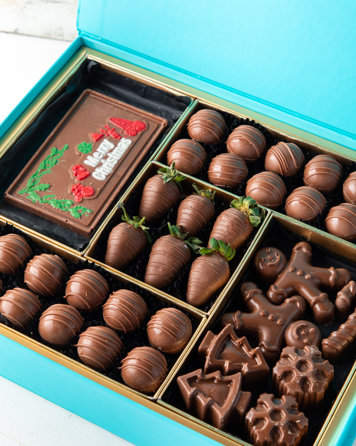 Assorted Christmas Greetings BoxChocolate & ConfectioneryYour Gift Contains: • 24 pieces Milk Chocolate Truffles in Peanut butter, Rice Crispy, Pistachio, Sepculoos and Hazelnut Gandoua and Pistachio Praline flavors • 50gms Milk Chocolate bar with Merry C