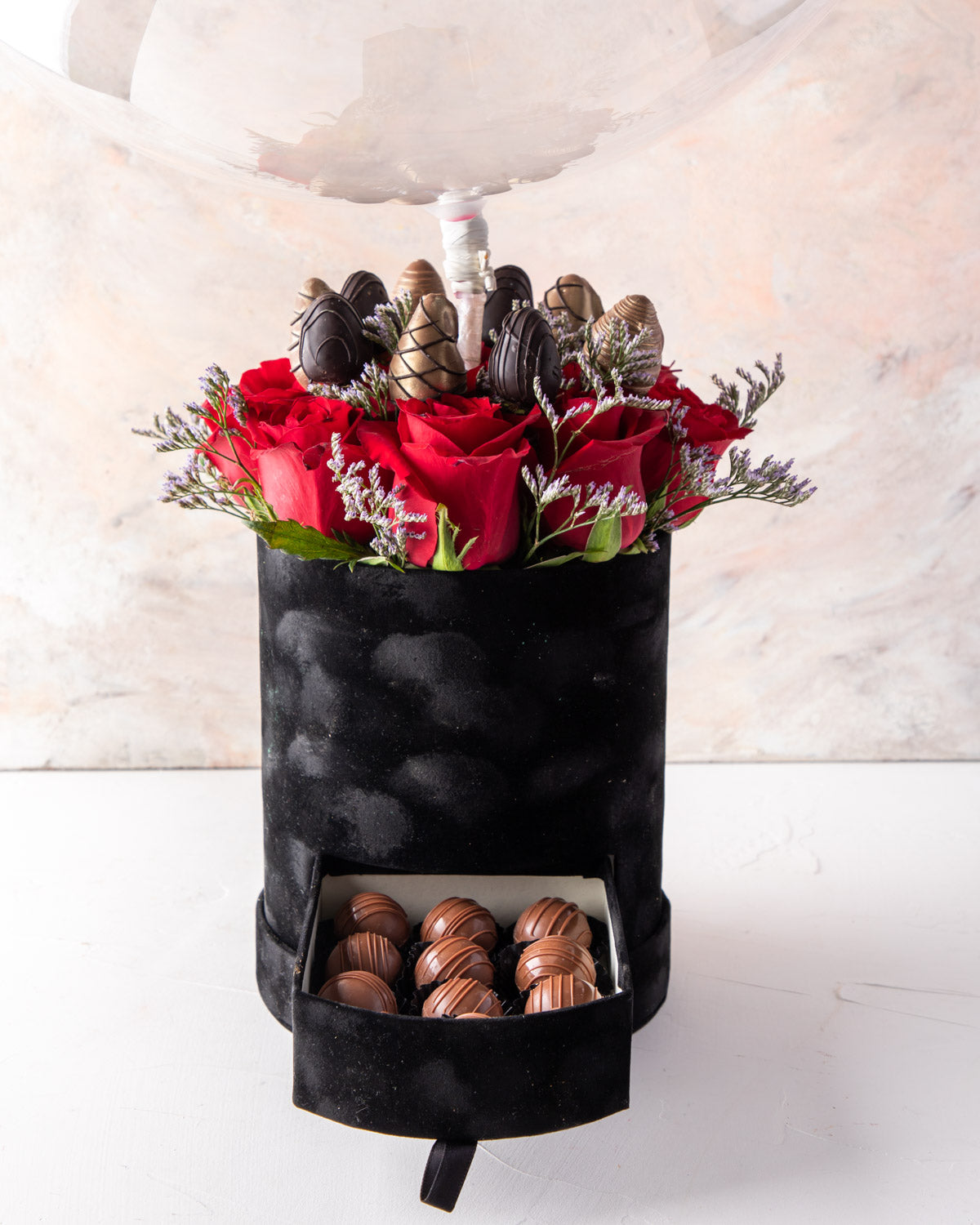 Christmas and New Year Combo by NJDFlowersYour Gift Contains: • 1 Large Balloon with Merry Christmas / Happy New Year message • 11 Red roses • 10 pieces chocolate covered strawberries • 16 pieces Milk chocolate truffles Box Size: LxBxH: 17X17X64CM HANDLIN