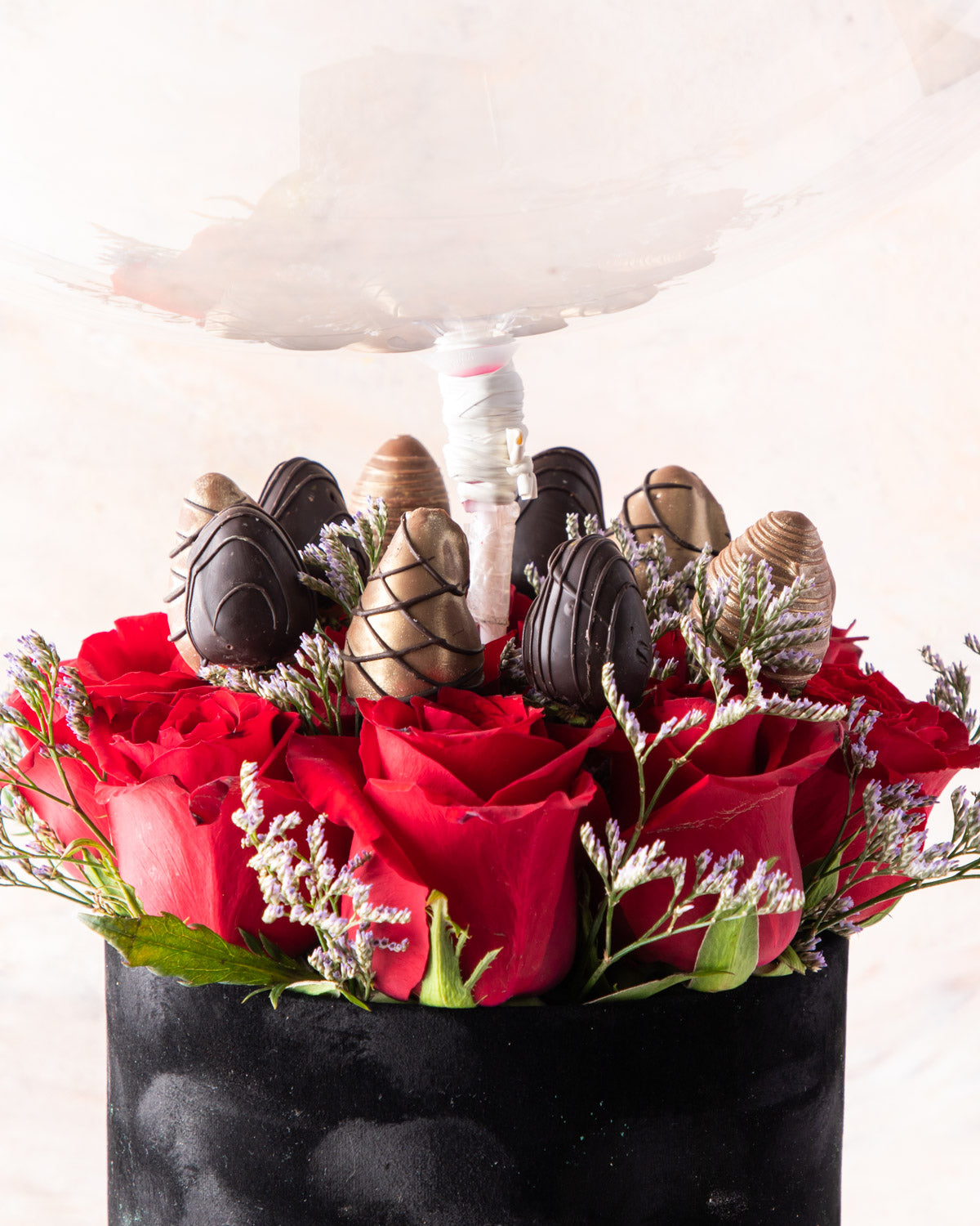 Christmas and New Year Combo by NJDFlowersYour Gift Contains: • 1 Large Balloon with Merry Christmas / Happy New Year message • 11 Red roses • 10 pieces chocolate covered strawberries • 16 pieces Milk chocolate truffles Box Size: LxBxH: 17X17X64CM HANDLIN