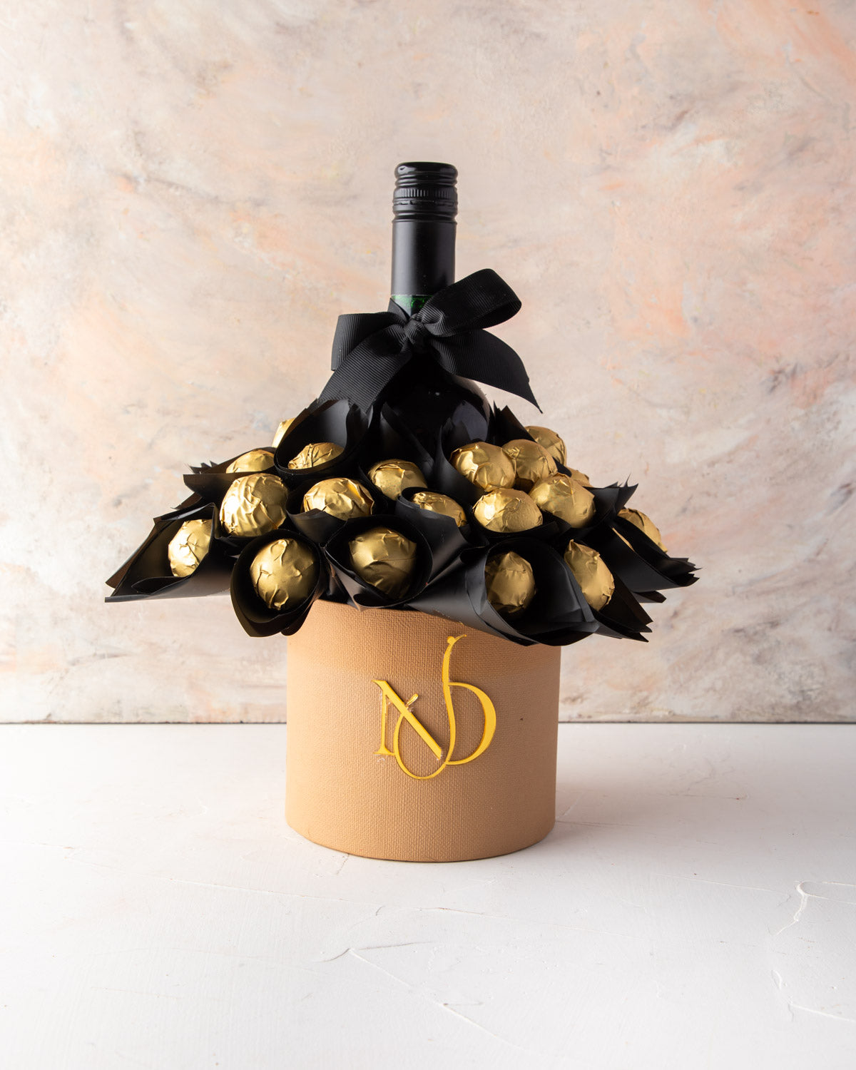 Truffles and VINA’0° le Merlot Hamper by NJDChocolate & ConfectioneryYour Gift Contains: • 35 pieces Milk chocolate truffles Flavors: Lotus, Salted Caramel, Speculoos, Peanut Butter, Pistachio Praline • Merlot Box Size: LxBxH: 13x13x30cm HANDLING AND STOR