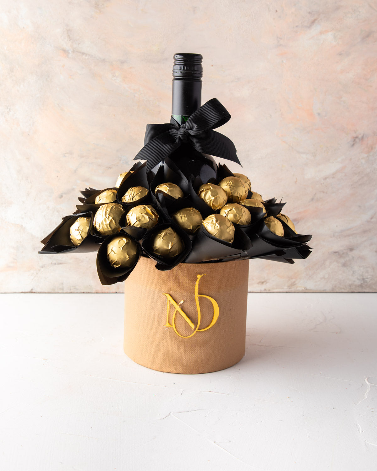 Truffles and VINA’0° le Merlot Hamper by NJDChocolate & ConfectioneryYour Gift Contains: • 35 pieces Milk chocolate truffles Flavors: Lotus, Salted Caramel, Speculoos, Peanut Butter, Pistachio Praline • Merlot Box Size: LxBxH: 13x13x30cm HANDLING AND STOR