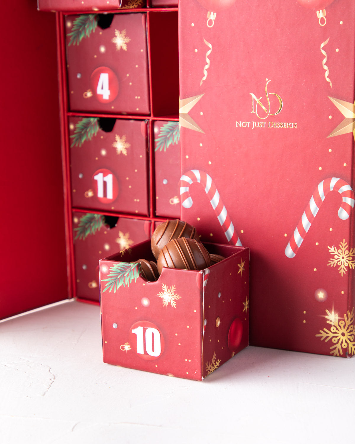 Chocolate Advent Calendar by NJDChocolate & ConfectioneryYour Gift Contains: 12 days chocolate Advent calendar by NJD 1. 1 box Milk chocolate covered Oreos 2. 1 box Dark chocolate covered Oreos 3. 1 box Milk chocolate Truffles 4. 1 box Dark chocolate Truf