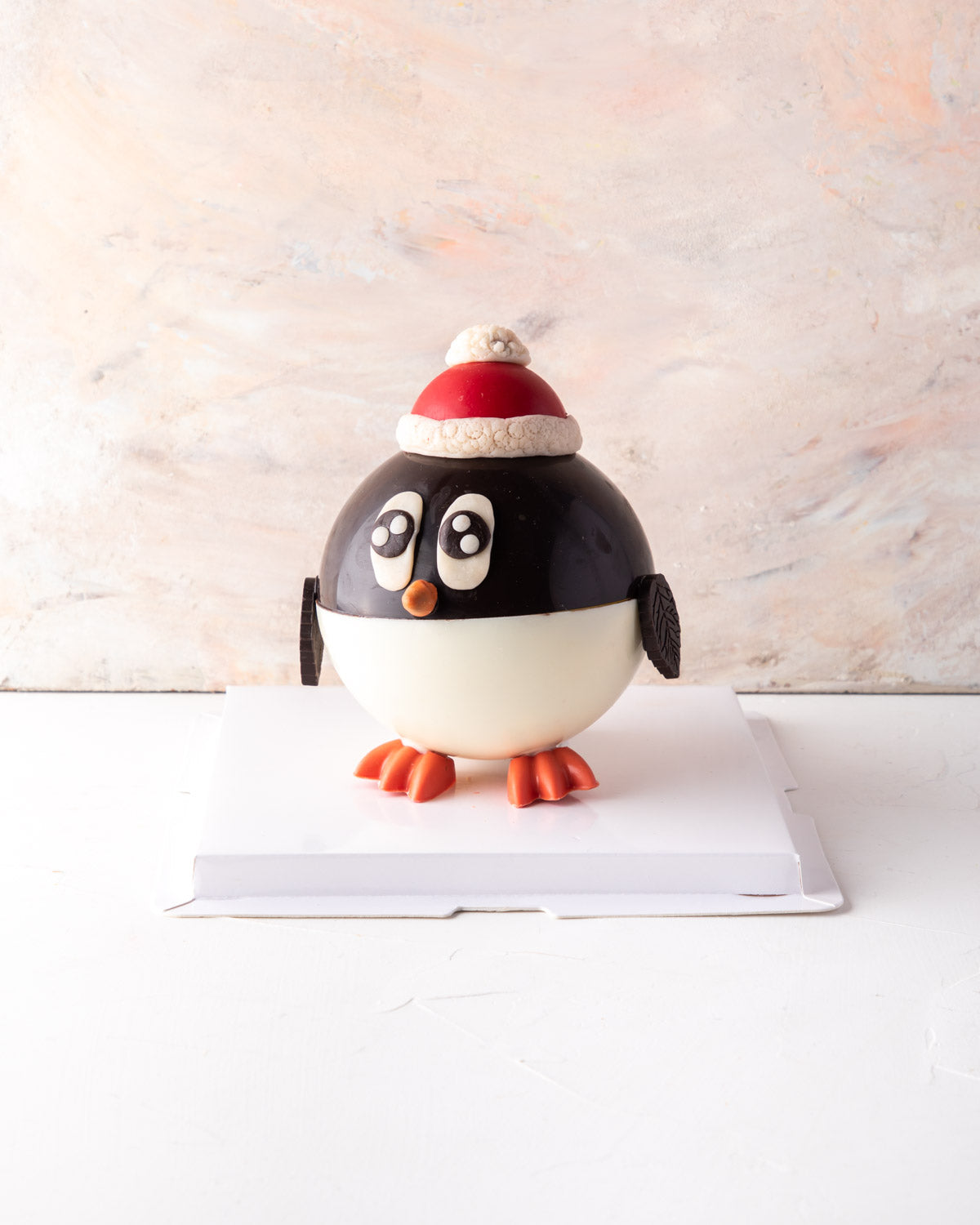 Piñata Penguin by NJDChocolate & ConfectioneryYour Gift Contains: • 300gms Dark and White chocolate Piñata Penguin • Filled with 10 pieces Christmas theme milk chocolate Box Size: LxBxH: 23.5X23.5X18cm HANDLING AND STORAGE Keep away from direct heat and s