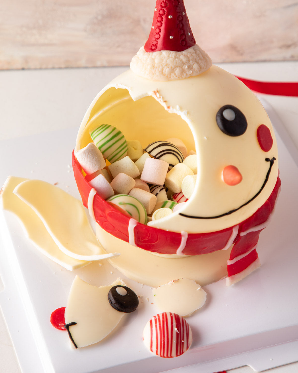 Piñata Snowman by NJDChocolate & ConfectioneryYour Gift Contains: • 3D Edible Snowman made in White and colored Chocolate • Weight approx. 300gms (20gms (+/-) • Filled with Marshmallows and 10 White assorted chocolates Box Size: LxBxH: 23.5X23.5X18cm HAND