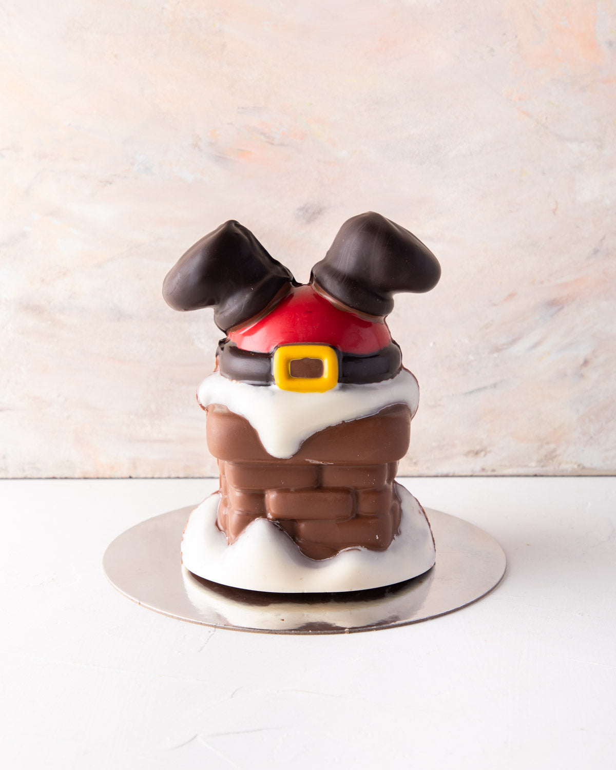 Santa comes down Chimney by NJDChocolate & ConfectioneryYour Gift Contains: • 550gms Milk and colored chocolate Santa stuck in a chimney design • chocolate size: 12.5x17cm Box Size: LxBxH: 23.5x23.5x22cm HANDLING AND STORAGE Keep away from direct heat and