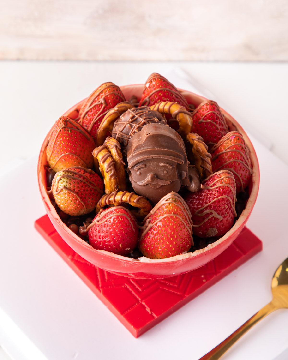 Season's Special Indulgence by NJDChocolate & ConfectioneryYour Gift Contains: • Edible chocolate bowl with Hazelnut praline • 12 fresh strawberries • Pretzels • 3 Rocher • 1 Spoon • Total weight: 750gms (20gms +/-) Box Size: LxBxH: 23x23x18cm HANDLING AN