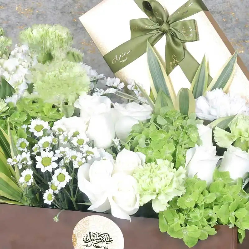 Eid Floral Hamper BrownGifts and HampersHamper Includes: Bateel Premium Stuffed Dates 450gm 9 White Roses 2 Green Hydrangea 5 Stems Green Carnations 3 Stems White Matthiola 3 Stems White Chrysanthemum Leaves - 2 Stems Song of India and 3 Stems Eucalyptus