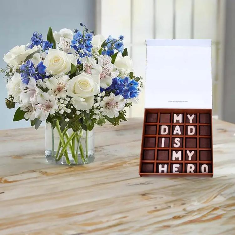 Blue and White Flowers and My Hero Dad ChocolatesChocolate & ConfectioneryMy Dad Is My Hero Chocolates By Sweecho, 2 Blue Delphinium, 10 White Roses, 8 White Alstroemeria, 8 White Carnations, Leaves and Fillers : Single Ruscus and Gypso, Cylinder Glass Va