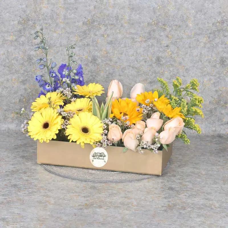Floral Eid Wishes GoldenGifts and HampersProduct Description 12 Peach Roses 5 Stems Yellow Gerbera 3 Sunflowers 2 Stems Dark Blue Delphinium 3 Stems Soliduster 2 Stems White Wax Flowers Leaves - 1 Song of India and 5 Stems Green Ruscus Prepeared in a Gold
