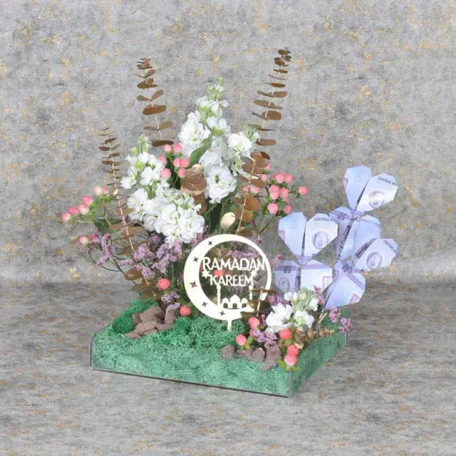 Ramadan Dirham Flower WishesGifts and Hampers6 Notes of AED 50 6 Stems White Matthiola 5 Pink Hypericum Leaves - 4 Stems Golden Sprayed Eucalyptus Fillers - 2 Stems Pink Limonium Decorated with Green Moss Ramadan Kareem Topper Prepared in Small Acrylic Tr