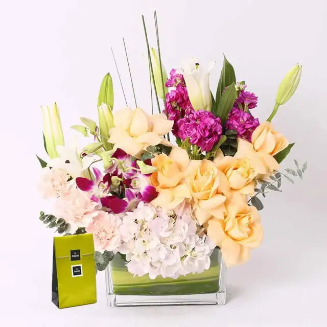 Tender Floral Arrangement and Deluxe Patchi ChocolatesGifts and Hampers100gm Deluxe Patchi Chocolates 1 White Hydrangea 6 Peach Roses 2 Stems of White Oriental Lilies 3 Purple Matthiola 3 Pink Carnations 2 Purple Orchid Leaves - 2 Eucalyptus and 3 Fleci G