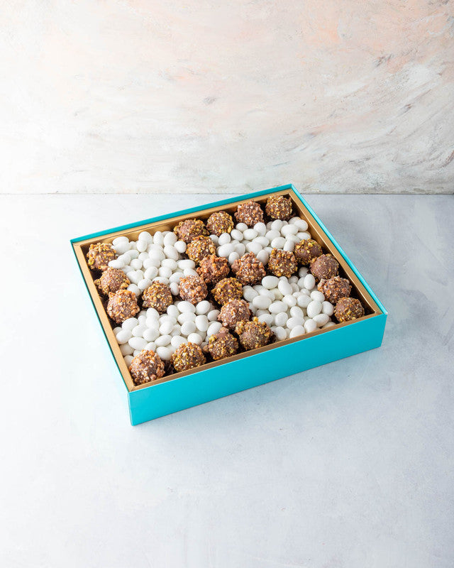 Diwali Swastik Collection by NJDChocolate & ConfectioneryYOUR GIFT CONTAINS Content: 22pcs Truffle 1kg Drageè Flavors: Assorted Belgian Truffles filled with caramelized Pistachio, Almonds, Nutella, Lotus, Peanut Butter and Salted Caramel Box dimensions: W