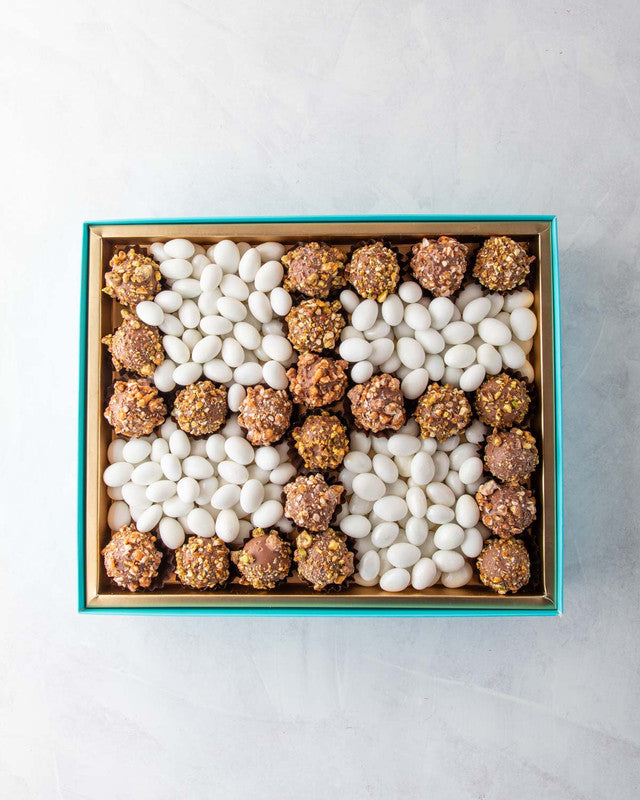 Diwali Swastik Collection by NJDChocolate & ConfectioneryYOUR GIFT CONTAINS Content: 22pcs Truffle 1kg Drageè Flavors: Assorted Belgian Truffles filled with caramelized Pistachio, Almonds, Nutella, Lotus, Peanut Butter and Salted Caramel Box dimensions: W