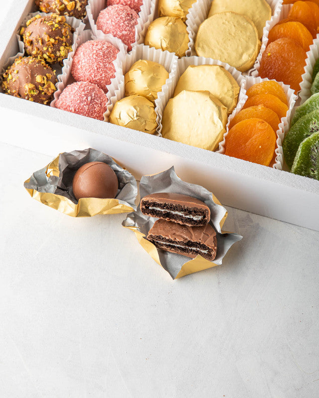 Seven of a kind by NJDNuts, Dates & Dried FruitsYOUR GIFT CONTAINS Content: Truffles 24pcs Chocolate covered Oreo coins 12pcs Dried Apricot 160gms Dried Kiwis 130gms Savory cookies 150gms Flavors: Truffles: Roasted Nuts, Rose & Coconut and Pralines Tray d